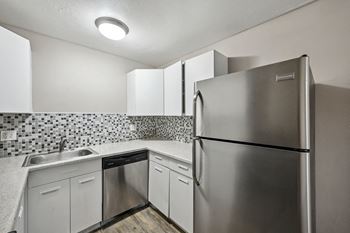 The kitchen has stainless steel appliances and white cabinets