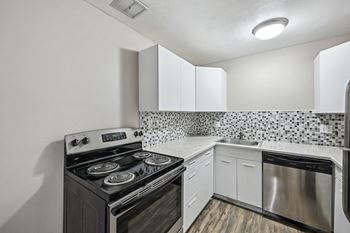 A kitchen with a black stove and white cabinets.
