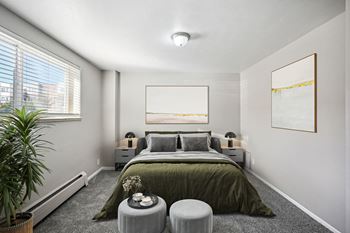 A bedroom with a large bed and a painting on the wall.