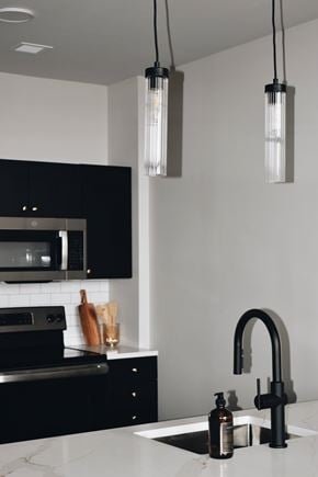 Hartford apartment for rent - A modern kitchen with black cabinets and a white countertop. at The 55 Elm Club Apartments, Hartford, Connecticut