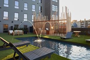 Norwalk apartment for rent - a pool with water sprinklers in front of a building
