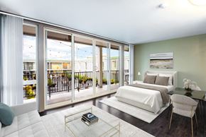 Seattle apartment for rent - A bedroom with a large bed and a balcony with a view of the outside.
