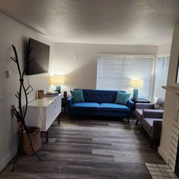 Seattle apartment for rent - A living room with a blue couch and a wooden floor.