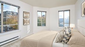 Seattle apartment for rent - A bedroom with a large bed and a view of the city.