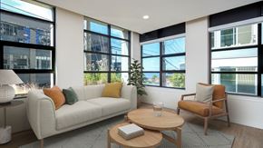 Seattle apartment for rent - A living room with a white couch, a wooden coffee table, and a chair.