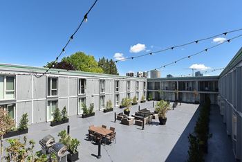 A courtyard with tables and benches on a roof of a building