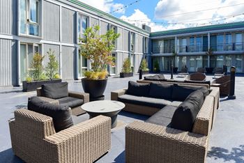 A patio area with couches and chairs and tables in front of a building
