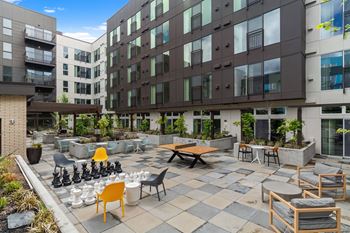 An outdoor patio with tables and chairs at an apartment building