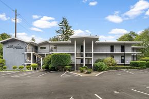 Issaquah apartment for rent - A large white building with a parking lot in front.