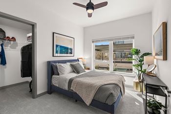 A bedroom with a bed and a ceiling fan