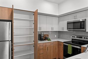 A kitchen with white cabinets and a black stove and a refrigerator
