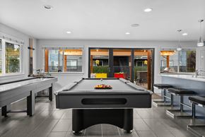 Tacoma apartment for rent - A pool table is in the middle of a room with a bar and a balcony.