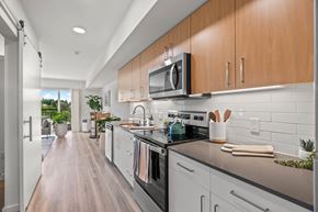 Seattle apartment for rent - A modern kitchen with white cabinets and a black countertop.