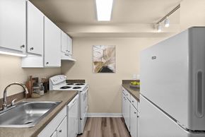 Issaquah apartment for rent - A kitchen with white cabinets and a white fridge.
