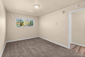 Issaquah apartment for rent - A room with a carpeted floor and a window showing trees outside.