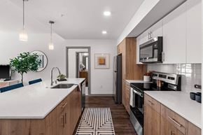 Tacoma apartment for rent - A modern kitchen with wooden cabinets and a white countertop.