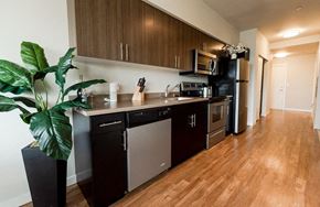Kent apartment for rent - A kitchen with dark wood cabinets and stainless steel appliances. at The Platform, Kent, WA, 98032