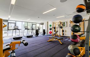 Seattle apartment for rent - A gym with a variety of equipment including weights and exercise machines.