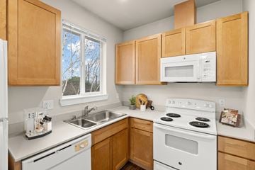 Bellevue apartment for rent - A kitchen with wooden cabinets and white appliances.