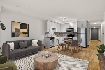 Seattle apartment for rent - A modern living room with a grey couch and a coffee table.