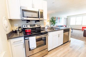 A kitchen with stainless steel appliances and white cabinets