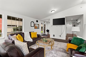 Puyallup apartment for rent - A living room with a brown leather couch and a glass coffee table.