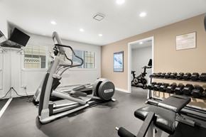 Puyallup apartment for rent - A gym with a treadmill, weights, and exercise equipment.