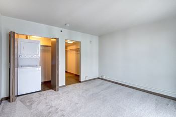 The living room of an apartment with a refrigerator and a closet