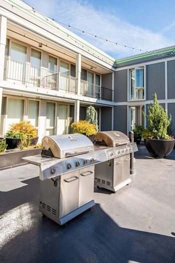 Two stainless steel barbecue grills in front of a building