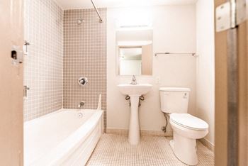 A bathroom with a sink toilet and a bath tub