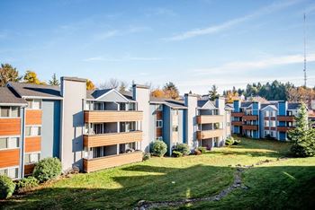 A row of modern apartment buildings with green lawns in front.