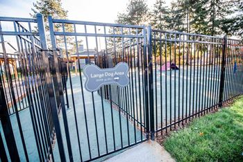 A black metal gate with a sign that says large dog area.