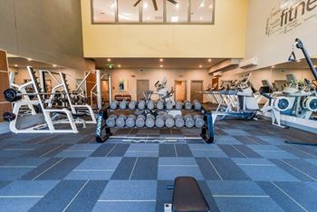 A gym with a variety of equipment including weights and machines.