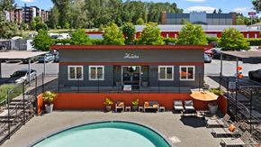 Renton apartment for rent - A pool is located outside of a building with a red and grey exterior.