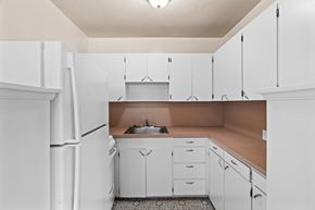 Seattle apartment for rent - A kitchen with white cabinets and a brown countertop.