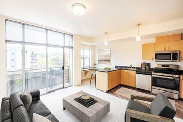 Sammamish apartment for rent - A modern living room with a grey sofa and a coffee table in the center.