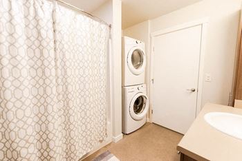 A white washing machine sits in a small laundry room.