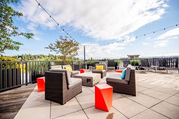 A patio with wicker furniture and a view of the sky.