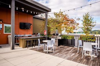 A patio with a table and chairs and a tv on the wall.