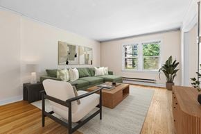 Seattle apartment for rent - A living room with a green couch, a chair, a coffee table, and a painting on the wall.