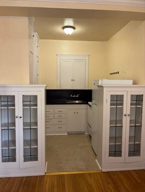 Seattle apartment for rent - A kitchen with white cabinets and a black countertop.