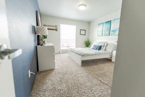 Renton apartment for rent - A bedroom with a bed, dresser, and window. at The Aviator, Washington