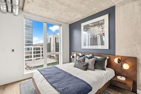 Seattle apartment for rent - A bedroom with a large bed and a view of the city.