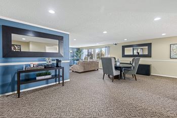 A living room with a blue accent wall and a large mirror.