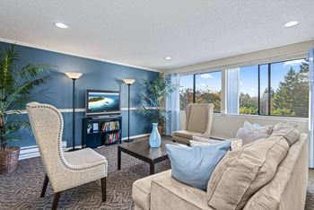 A living room with a chair, a sofa, a table, and a television.