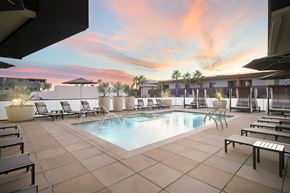 Scottsdale apartment for rent - A pool surrounded by lounge chairs and umbrellas.