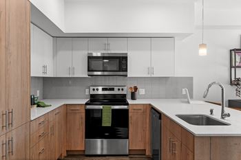 A kitchen with white cabinets and a stove and a sink