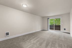 Lakewood apartment for rent - an empty living room with a large window and carpeting at Bellamy Park Apartments , Washington