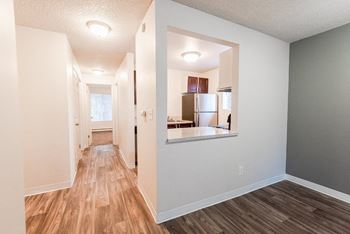 A renovated living room and kitchen with a hard wood floor