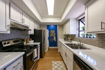 Peoria apartment for rent - A kitchen with white cabinets and a black refrigerator.